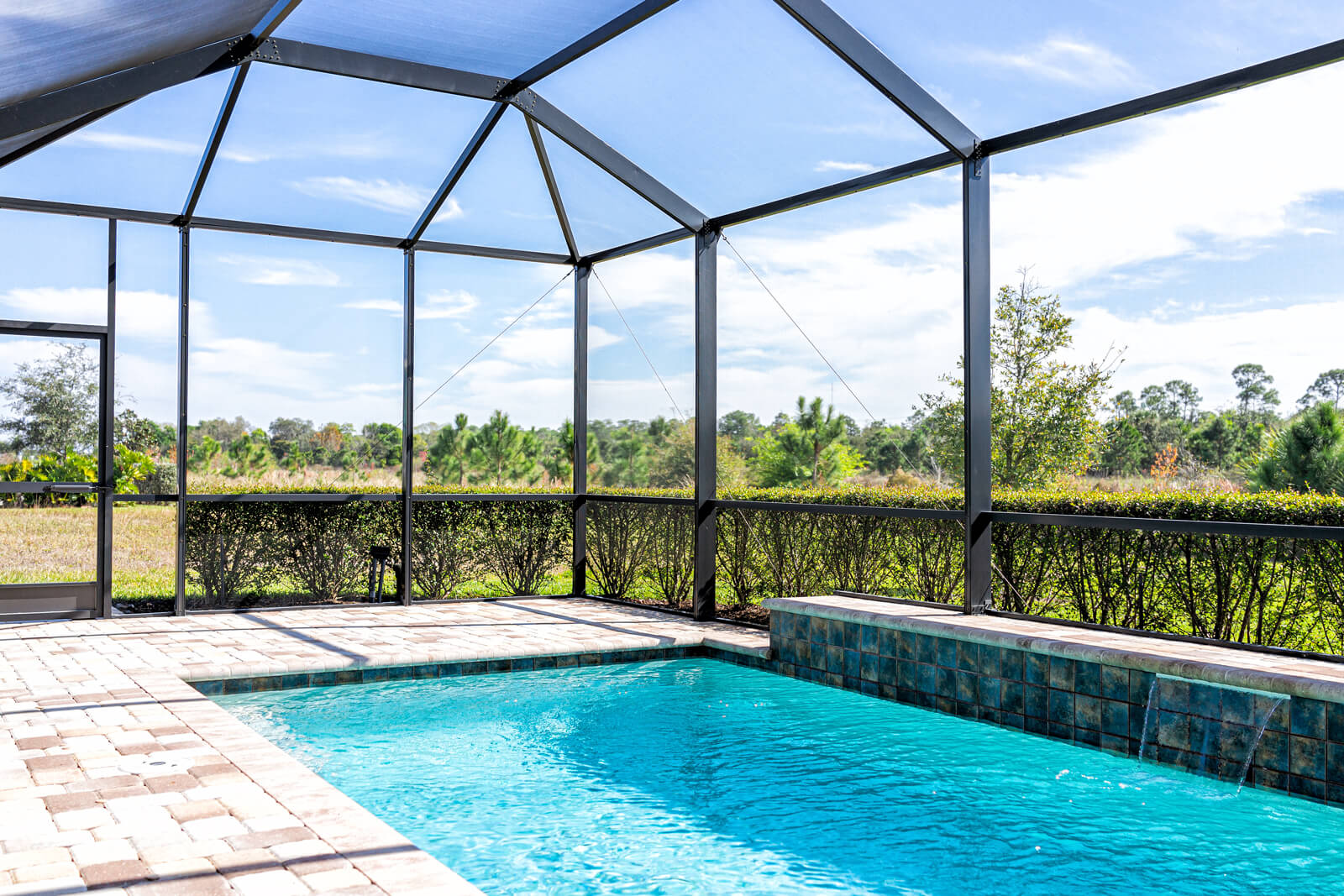 Modern contemporary home villa with screened in glass canopy lanai private pool with view of tropical lake in Florida with blue water in clean house